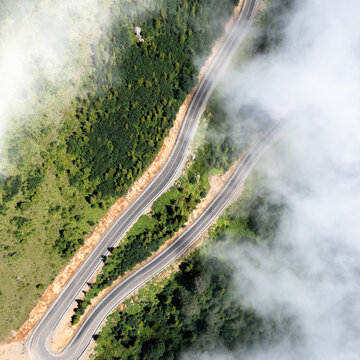 Gomismta switchback road in clouds top view, mountain serpentine through forest, Georgia aerial landscape, dramatic fog, scenic route, adventure travel concept