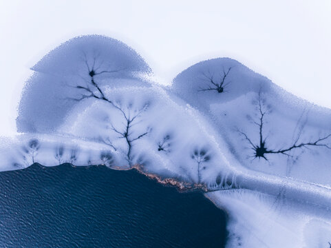 Landscape, tourism: Aerial view of frozen lake with ice patterns resembling trees, winter environment, Fusine lakes, Tarvisio, Friuli, Italy.