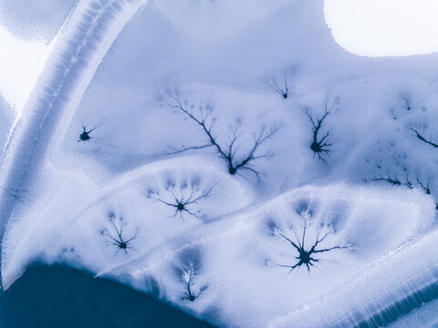 Landscape, tourism: Aerial view of frozen lake with ice patterns resembling trees, winter environment, Fusine lakes, Tarvisio, Friuli, Italy.
