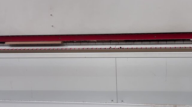 Industrial machine cutting wooden chipboard sheets in a furniture factory