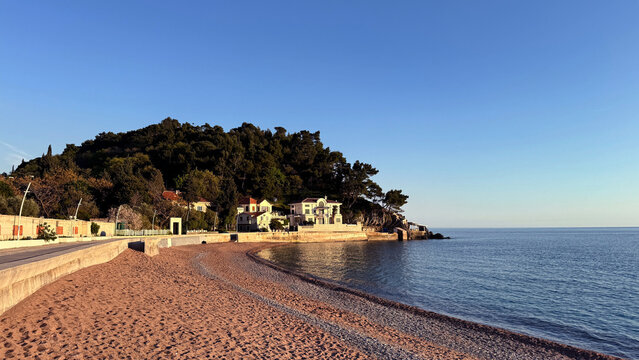 Petrovac beach at sunset with curved pebble shoreline and seaside villas