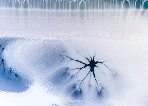 Ice texture background. Frozen lake surface with cracks resembling tree branches, winter landscape, Fusine lakes, Tarvisio, Friuli, Italy.
