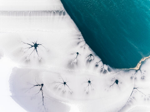 Winter landscape, aerial view of frozen lake with cracks, ice texture, nature background, Fusine lakes, Tarvisio, Friuli, Italy.