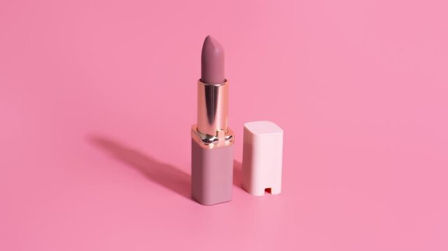Elegant Pink Lipstick with Gold Accent on Pastel Background