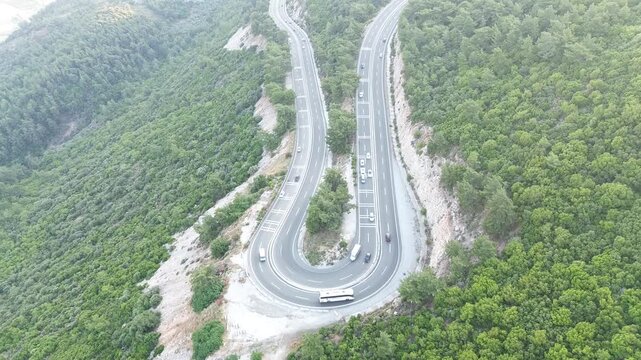 Aerial top-down view of a U-shaped highway curve with traffic