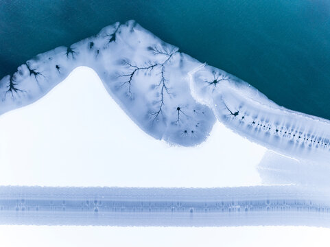 Aerial landscape of frozen lake with ice patterns, creating a unique nature background, Fusine lakes, Tarvisio, Friuli, Italy.