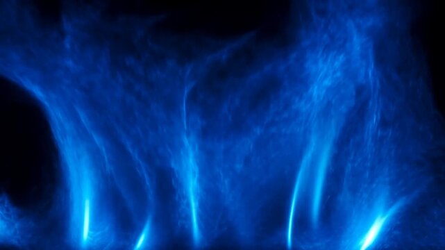 Slow motion tracking shot of blue flames rising and swirling against black studio background in controlled laboratory setting
