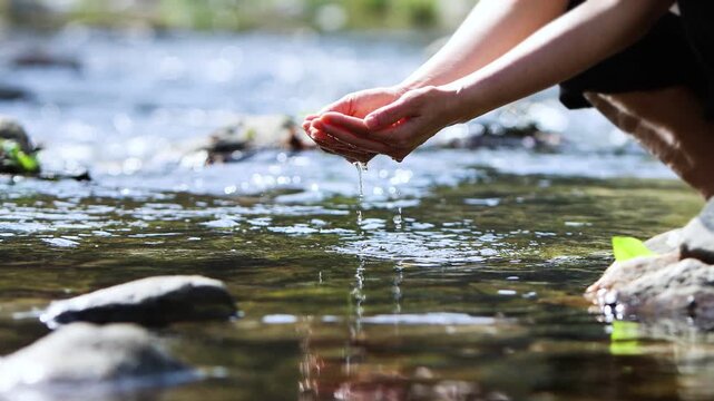 Holding clean, cool, and clear stream water in your hands, the concept of precious life-giving water and World Water Day background
