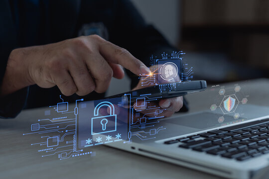 Professional using smartphone with virtual lock, fingerprint and cybersecurity icons beside laptop, showing secure mobile authentication and data protection.