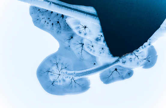 Abstract nature background of ice patterns on a frozen lake, aerial view, winter season, copy space.