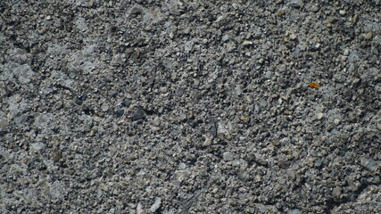 Detailed macro shot of weathered grey concrete pavement with small gravel aggregates © shufilm