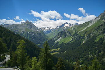 Fototapeta premium Scenic view of the winding Maloja Pass road with hairpin turns in the Swiss Alps, perfect for road trip themes