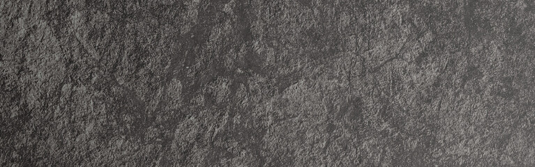 Dark gray slate background presenting a rough stone texture with a natural rocky surface, creating a rugged and weathered wall effect