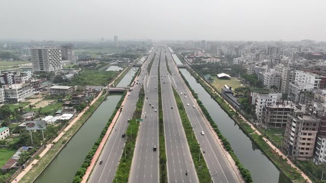Aerial drone flying backwards above a multi lane highway in dhaka
