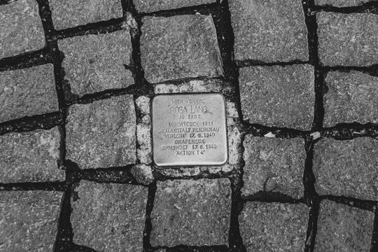 Konstanz, Germany- May 28, 2025: Rosa Lang Stolperstein memorial cube. Brass plate inscribed with the name and life dates of victims of Nazi extermination or persecution in black and white
