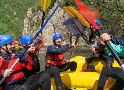 Rafting - hi-five with oars in a boat on a semi calm water of a river Struma, Bulgaria