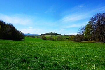 Piękna panorama gór Jesioniki z rozległymi łąkami i górskim krajobrazem. Niebieskie niebo i dobra pogoda podkreślają świeżość i przestrzeń natury. © Adam