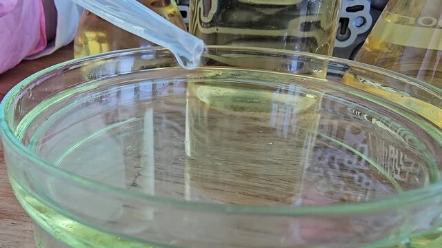 Experiment with different oils and liquid mixtures in a glass container on a wooden table