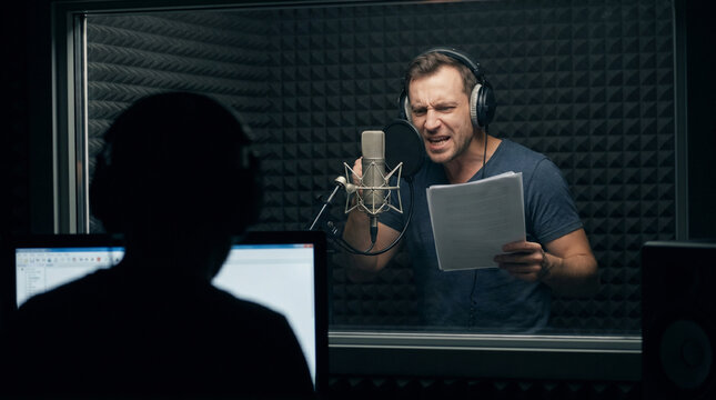 Intense male voice actor recording audio in studio