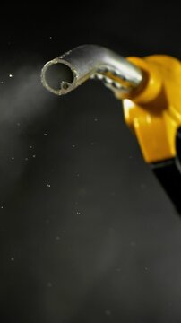 Super slow motion (1000 fps) fuel vapors escaping from gasoline nozzle, symbol of evaporation, depletion and fuel shortage. Minimal emissions on dark background, energy crisis concept.
