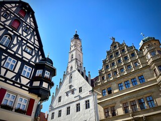 Fototapeta premium Rothenburg ob der Tauber's Town Hall in Bavaria, Germany, is a blend of Gothic and Renaissance architecture. The image shows its white tower with a steep roof and clock