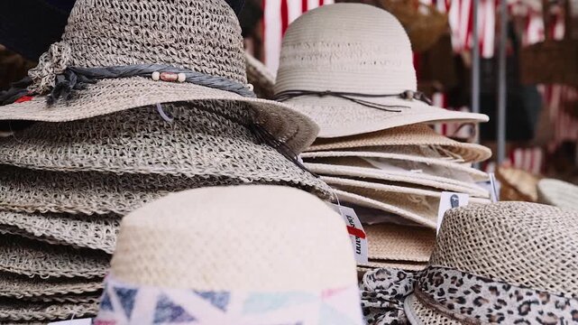 Gestapelte Strohh&uuml;te an Marktstand Sommermode Accessoires f&uuml;r Damen