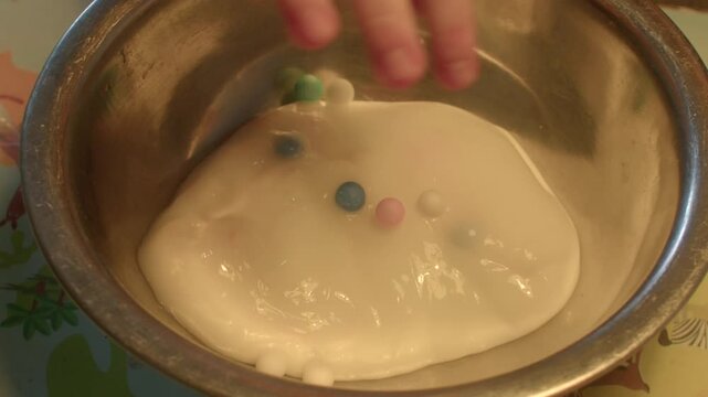 Unique slime craftsmanship. Artistic slime combining cheerful foam beads and fluid movement. Creative slime creation incorporating vibrant foam beads and seamless flowing motion