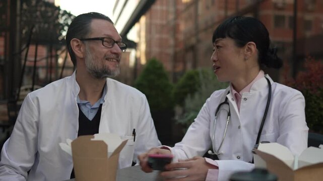Two doctors discussing patient case during lunch break