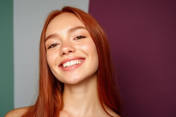 Fototapeta premium Redheaded woman smiling close up against multicolor backdrop