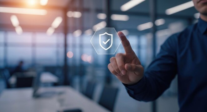 Finger taps digital shield icon on blurry office background