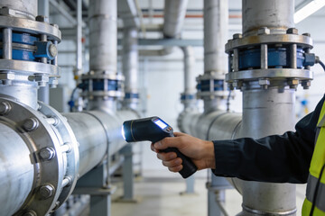 Industrial inspection with a flashlight on large pipes in a factory setting © Snide12