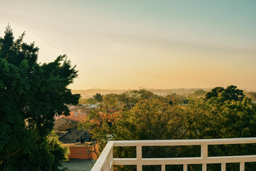 Fototapeta premium Misty sunrise over the residential rooftops and rolling hills of Moshi Town, Tanzania