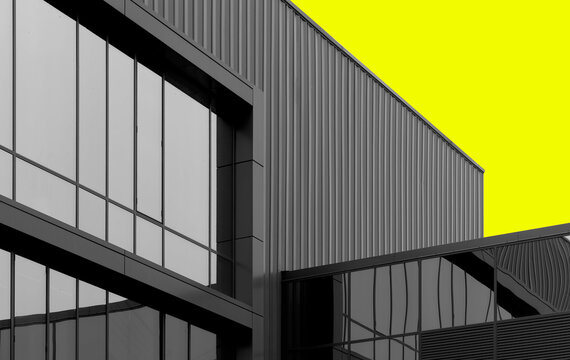 Modern industrial building facade with glass and metal cladding. Geometric architecture with clean lines and a minimalist exterior. Ideal for