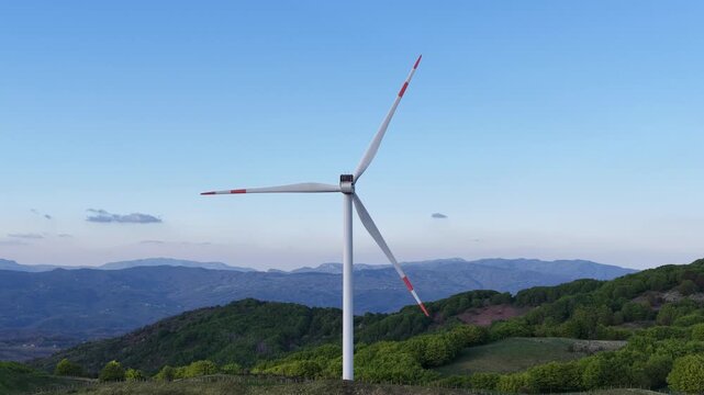 Aerial view of a large wind turbine at Passo Di Cento Croci on the green hills of the Apennines in Varese Ligure, Liguria, Italy.