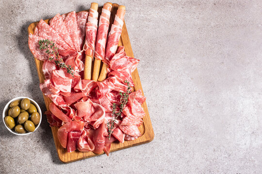 Charcuterie board. Antipasti appetizers of meat platter with salami, prosciutto crudo or jamon and olives.