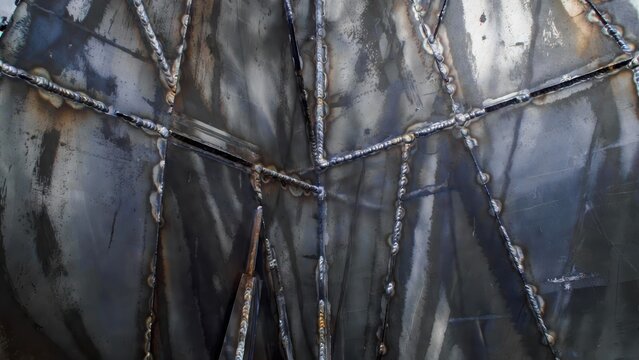 Abstract metallic texture with detailed welds and industrial surface imperfections, close-up