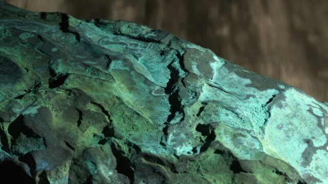 Close-up macro texture of weathered aged copper with verdigris patina and deep shadows