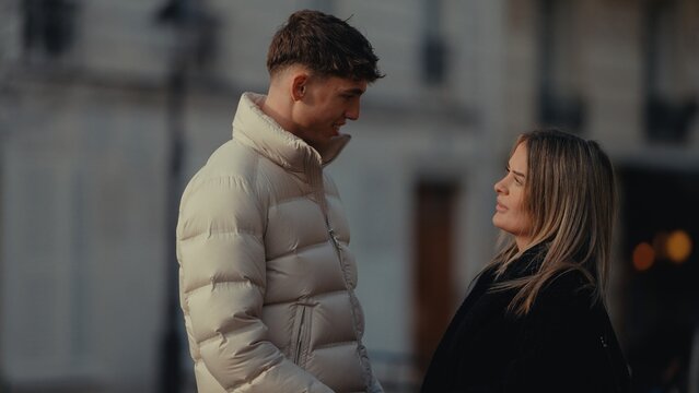 Romantic Couple In Paris France Looking At Each Other Wearing Winter Coats Love And Connection In Urban Setting City Background Relationships