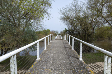 Obraz premium Concrete footbridge crossing sorraia river during flood in benavente