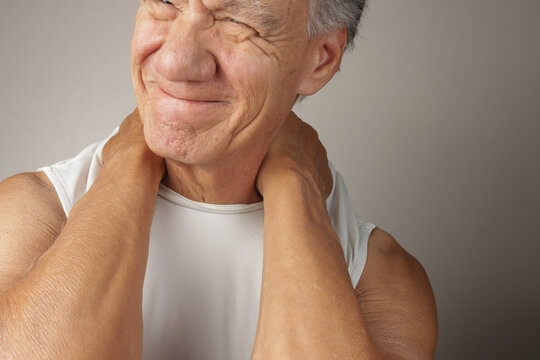 Older Man doing a self-massage on his upper back and shoulders
