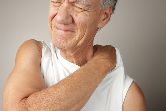 Older Man doing a self-massage on his upper back and shoulders