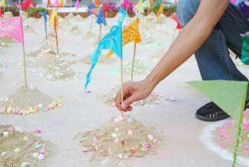 Naklejka premium Visitor Building Sand Pagoda at Wat Suthat to Join the Songkran New Year ceremony with colorful flags and communal ritual