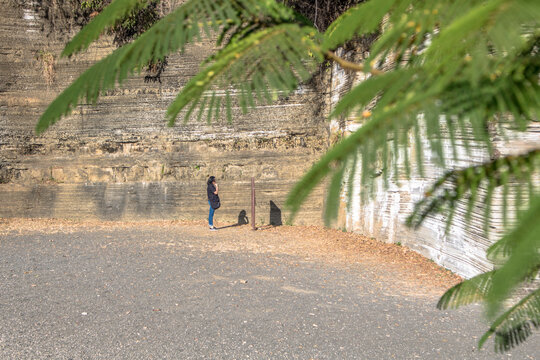 Itu, Sao Paulo, Brazil, July 26, 2018. Woman on the Varvito Geological Park, featuring layered sedimentary rocks formed during ancient glacial periods. 