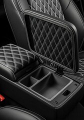 Fototapeta premium Open center console of a luxury vehicle showcases quilted leather upholstery with white contrast stitching.