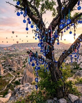 Tree with Nazar Evil Eye Amulets in Cappadocia with Balloons in Background
