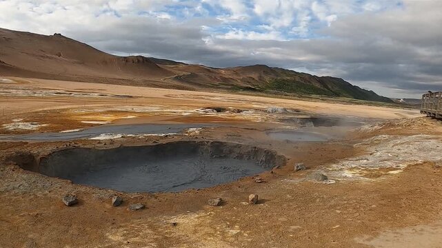 Large boiling mud pool at Hverir geothermal area with wooden walkway, Iceland