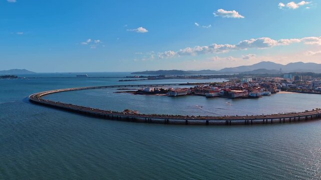 Cars move by the Marine Viaduct Cinta Costera in Casco Viejo, Panama City, Republic of Panama, North America. Historical part of the city on the peninsula in the backdrop. Aerial view.