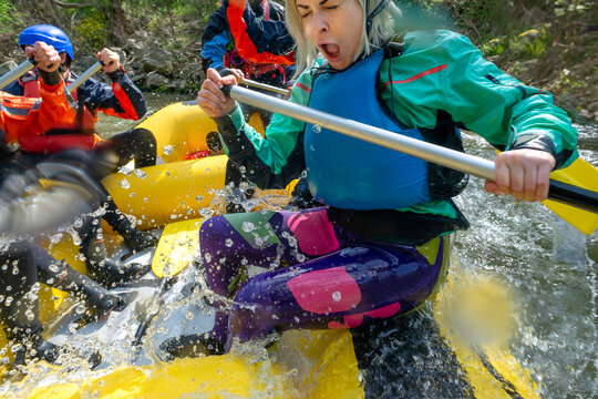 Rafting - a female reacts while peddaling on an inflatable boat being splashed in water