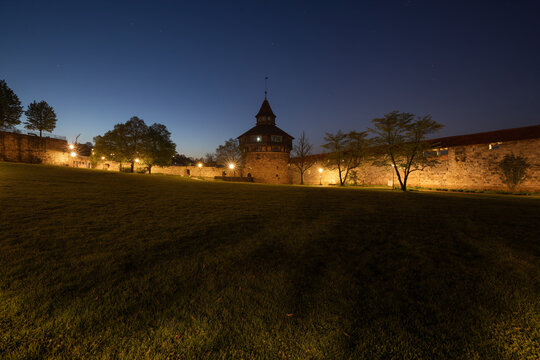 Illuminated castle fortification with Dicke Turm (Pirus communis) at dawn. Street lamps lighting the medieval site. Esslingen am Neckar, Baden-Wuerttemberg, Germany.