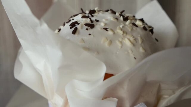Easter vanilla cupcake with marshmallow frosting and chocolate sprinkles, close-up macro of homemade festive bakery dessert in paper wrapper, sweet confectionery treat.